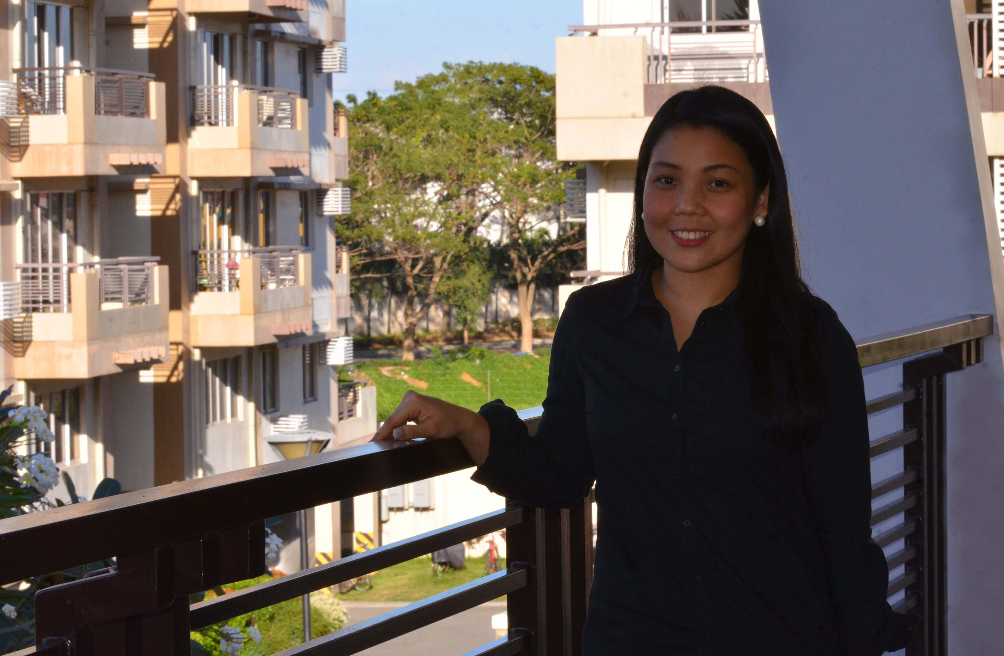 Asian woman having her photo shot in front of a condo unit